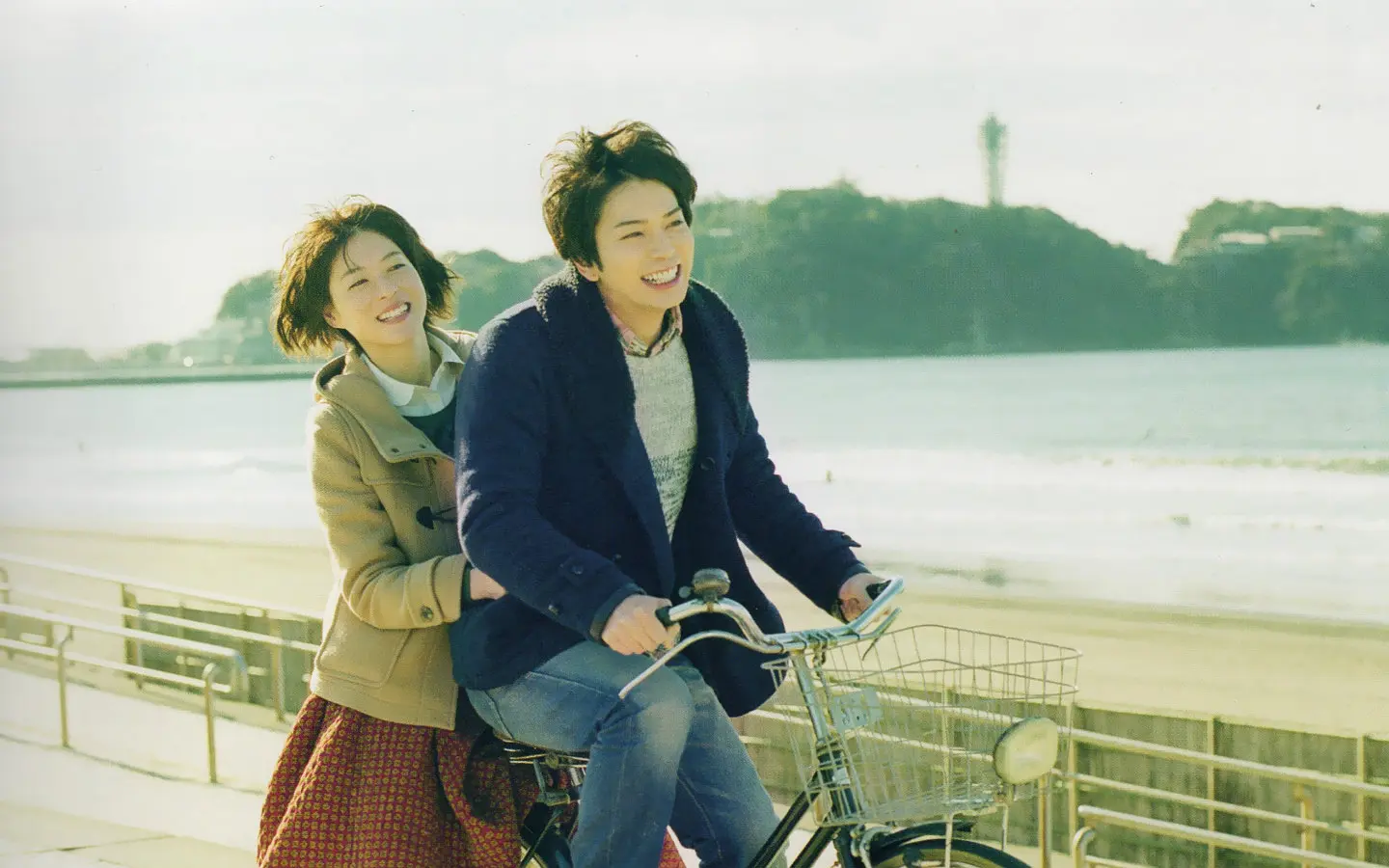 海辺を自転車で走る浩介と真緒